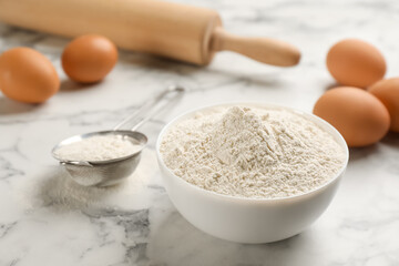 Bowl of flour and eggs on white marble table