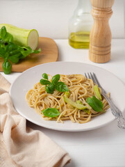 Pasta with pesto sauce, basil and zucchini.
