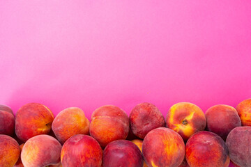 ripe peaches from below pink background
