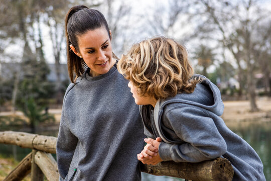 Smiling mom with son admiring nature in park