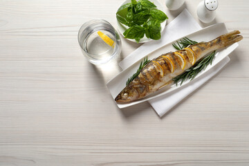 Tasty homemade roasted pike perch served on white wooden table, flat lay and space for text. River...