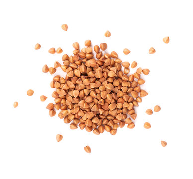 Roasted buckwheat grains, isolated on white background. Dry brown buckwheat groats. Top view.