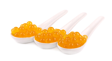 Yellow tapioca pearls for bubble tea isolated on white background. Tapioca pearls in ceramic spoon.