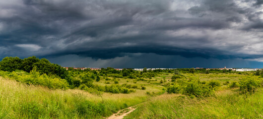 Obraz premium Dramatic view of a shelf cloud over a field, horizontal cloud formation, panorama view.