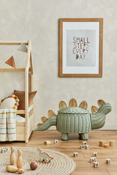 Creative composition of cozy scandinavian child's room interior with mock up poster frame, plush and wooden toys and textile decorations. Neutral wall, carpet on the parquet floor. Template.