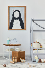 Stylish scandinavian child's room interior with mock up poster frame, creative bed, wooden cube, plush and wooden toys and hanging textile decorations. Grey wall, carpet on the floor. Template.