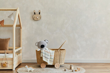 Stylish composition of cozy scandinavian child's room interior with bed, rattan basket, plush and...