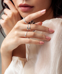 Beautiful young girl posing hand wearing rings and jewellery touching her chin and lip - obrazy, fototapety, plakaty