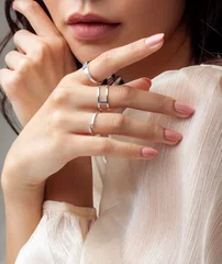 Photo sur Aluminium ManIcure Beautiful young girl posing hand wearing rings and jewellery touching her chin and lip
