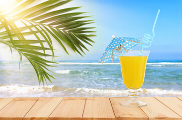 image of tropical and exotic fruit coctail over wooden table infront of sea landscape background