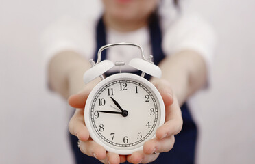 woman hands holding white alarm clock close up photo