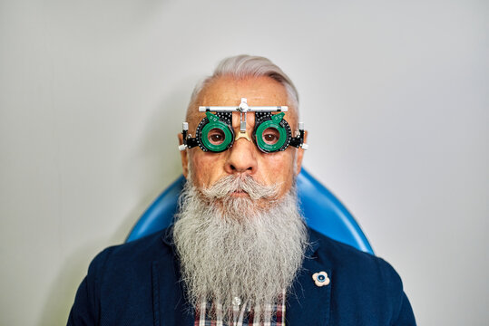 Senior man in eye test glasses in clinic