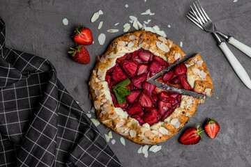 galette with strawberries and mint on dark background