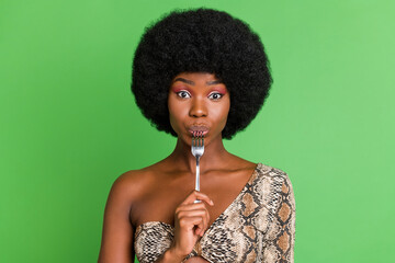 Photo of adorable shocked dark skin woman dressed snake top trying tasty dish isolated green color background