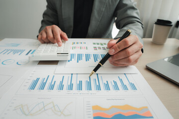 Businessman pointing at graph and chart to analysis use for plans to improve quality, business finances and accounting concept