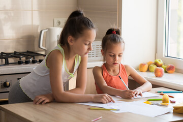 Obraz na płótnie Canvas Older sister helping younger sister to do her homework for school