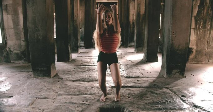 Zooming in Shot of Blonde Female Dancing Inside a  Cambodian Temple 
