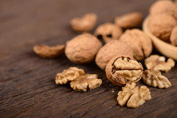 whole and peeled dried walnuts on wooden backbground