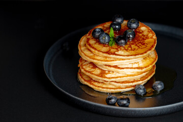 Stack of blueberry pancakes with maple syrup
