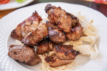 Pork kebab on a plate. Close view