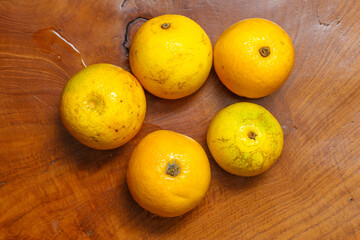 Fresh baby oranges on wooden table. All things yellow. Top view.