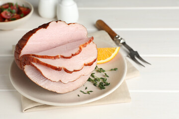 Cut delicious ham on white wooden table
