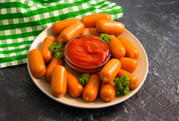 sausages with ketchup on a concrete background