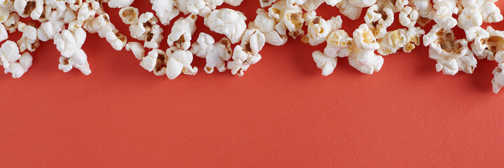 Popcorn on yellow or orange background banner with copy space. Top view.