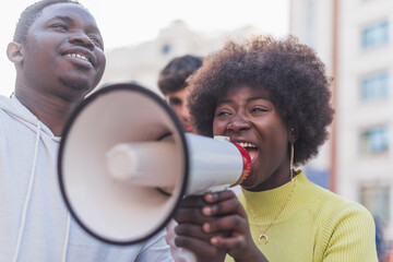 Black woman screaming in loudspeaker during demonstration in city