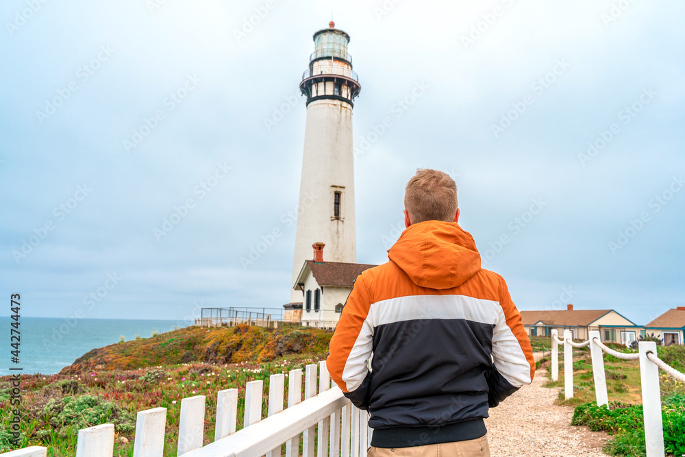 Wall mural Rear view of a young man at Pigeon Point Lighthouse, West Coast of California