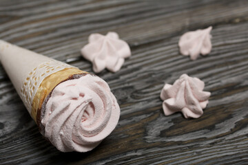 Waffle cones with marshmallows. On brushed pine boards.