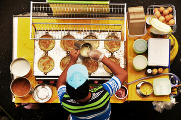 Filipino chef vendor cooking local street food philippine style at hawker shop for sale philippine people and foreign traveler customer eat drink at intramuros square of Maynila in Manila, Philippines