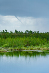 A funnel cloud, probably a waterspout, over the Cameron Prairie National Wildlife Refuge in Cameron Parish, Louisiana, a wetland habitat for native wildlife and plant species.