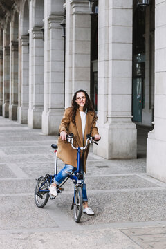 Smiling female biker on bicycle on city street