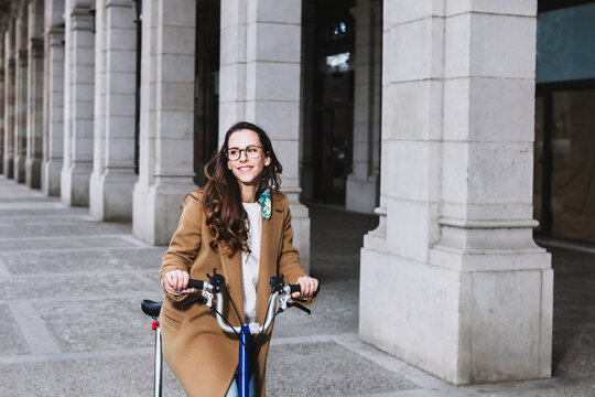 Smiling female biker on bicycle on city street