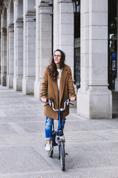 Smiling female biker on bicycle on city street