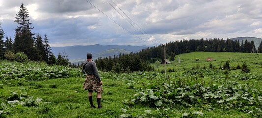 A man stands near the mountains