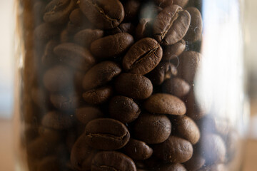 Très gros plan sur des grains de café dans un bocal en verre.
