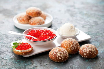 Homemade Keto buns from fathead dough with red caviar and butter on serving board, selective focus