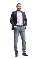 Full length portrait of a man in jeans and suit posing with hands in pockets and smiling