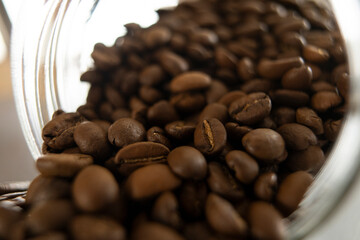 Gros plan de grains de café renversés d'un bocal.