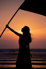 旗を持った女性のシルエット