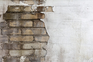 Brick wall with crumbling plaster