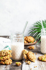 Oatmeal cookies and milk in glass jars.