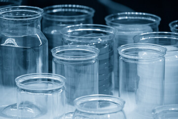 The group of transparent plastic container in the light blue scene. Hi-technology container products manufacturing process concept.