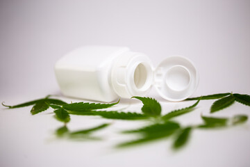 white jar with cannabis leaves on a white background.
