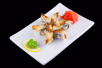 Unagi kani - sushi roll with crab, eel, tomato, cucumber, mayonnaise, sesame isolated on black background
