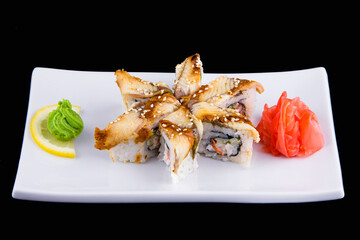 Unagi kani - sushi roll with crab, eel, tomato, cucumber, mayonnaise, sesame isolated on black background