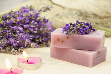 Natural handmade lavender soap and lavender flowers on gray background.