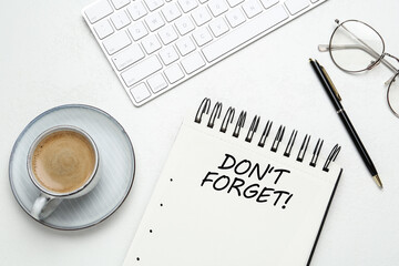 Reminder DON'T FORGET written in notebook on white table, flat lay